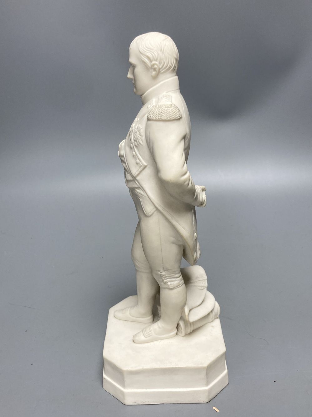 A Robinson & Leadbeater parian figure of Napoleon, standing on shaped square base, 25cm